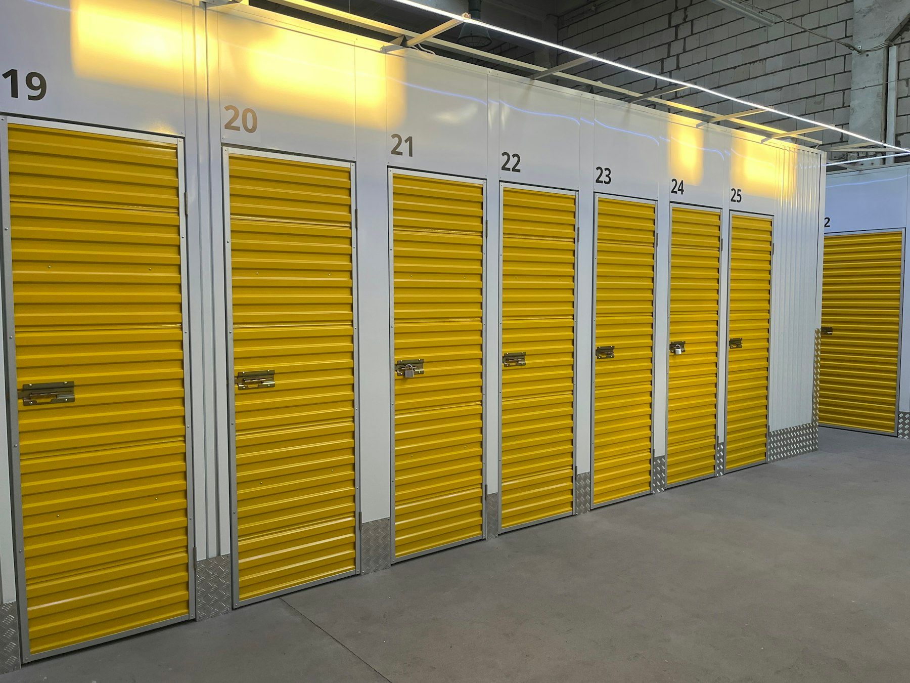 Row of storage units with yellow roller doors