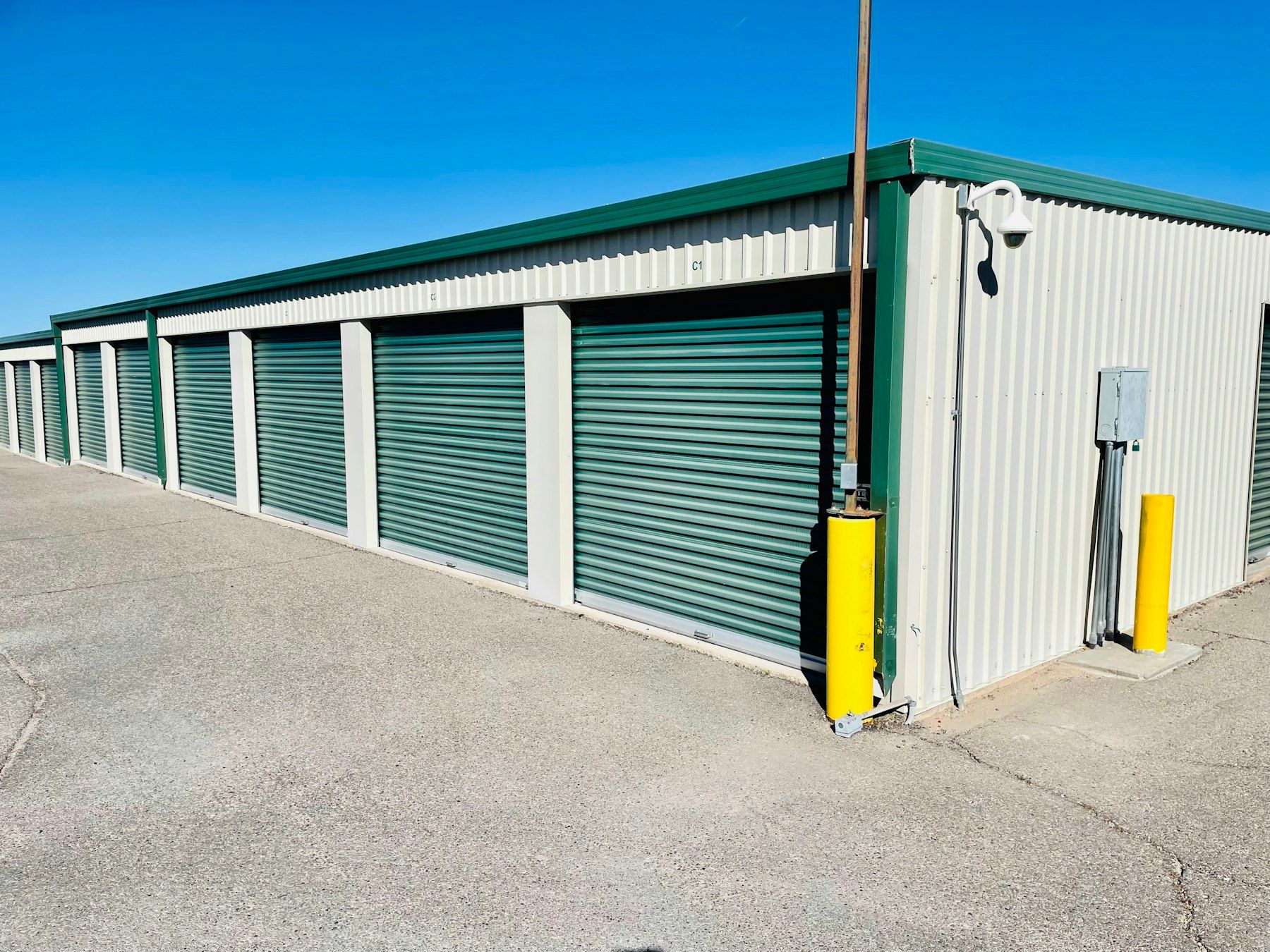 Row of drive-up storage units under a blue sky