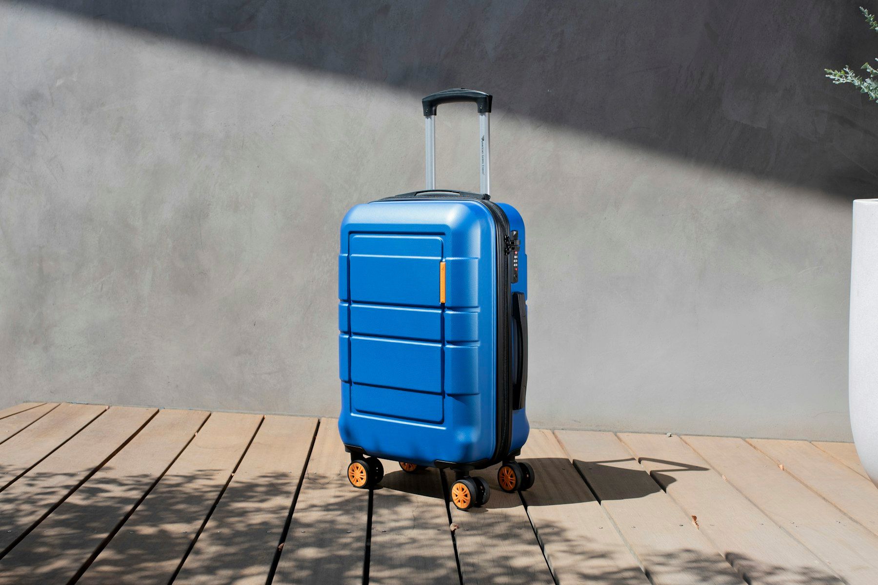 Blue cabin suitcase standing on a wooden floor