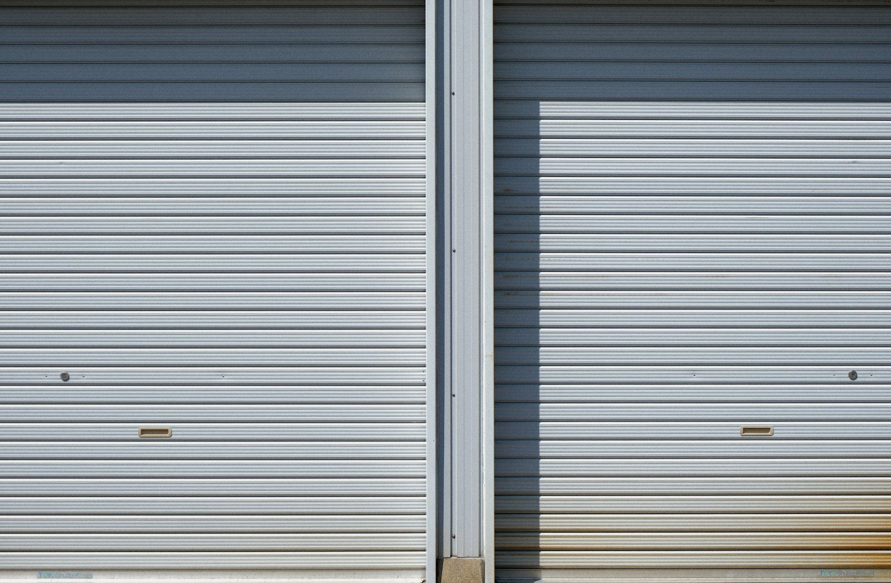 Two closed metal roller doors of storage units
