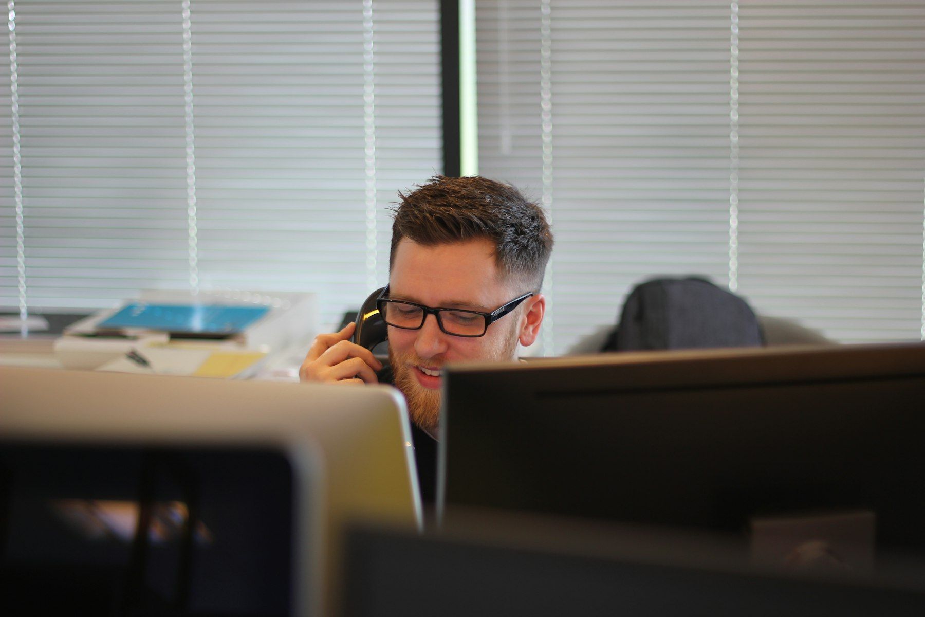 Staff member answering a customer call at his desk