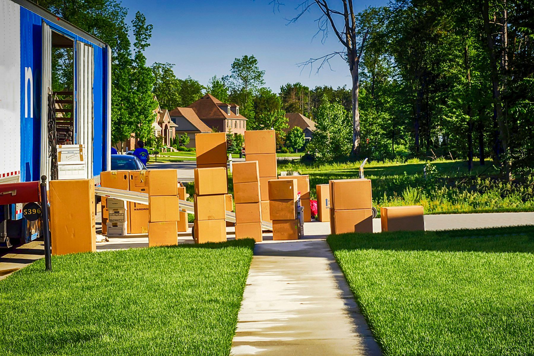 Moving boxes on a lawn beside a removal truck