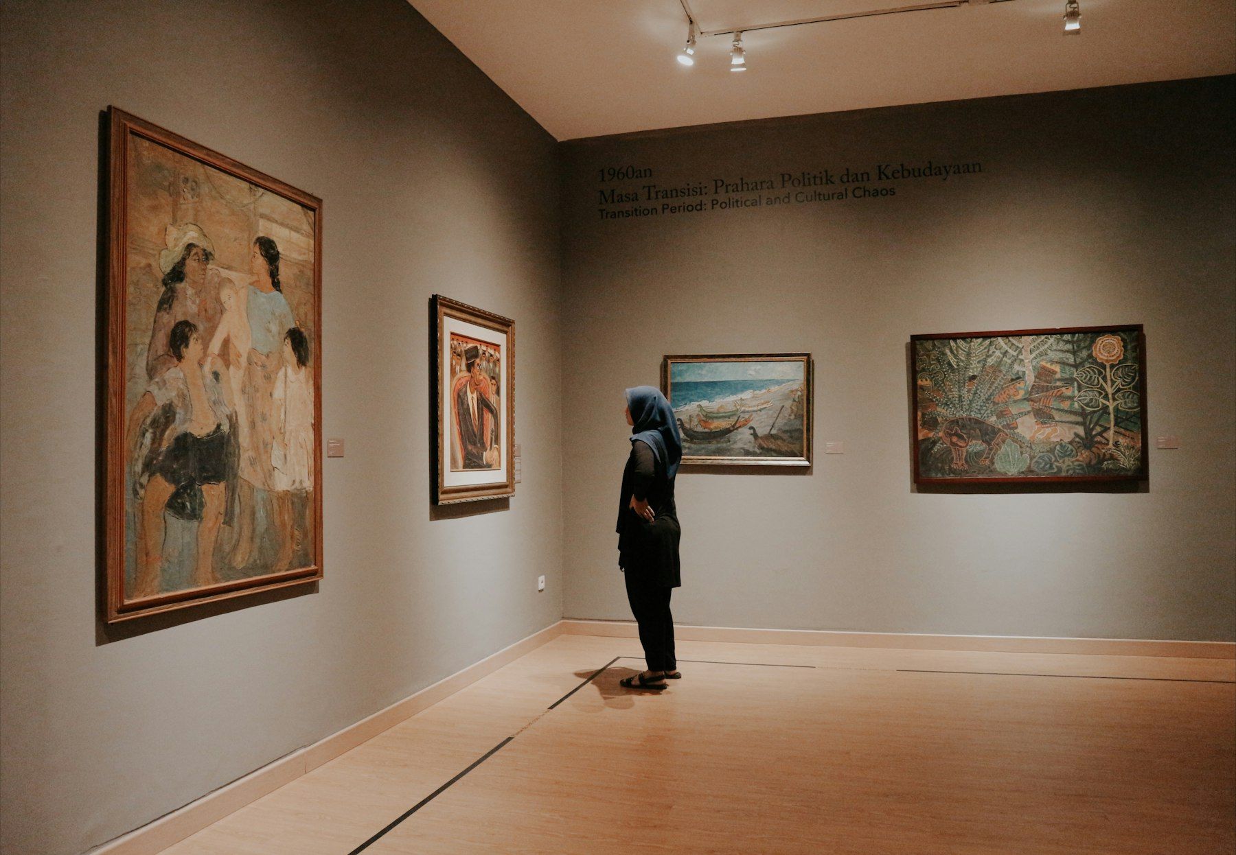 Visitor looking at paintings in a gallery