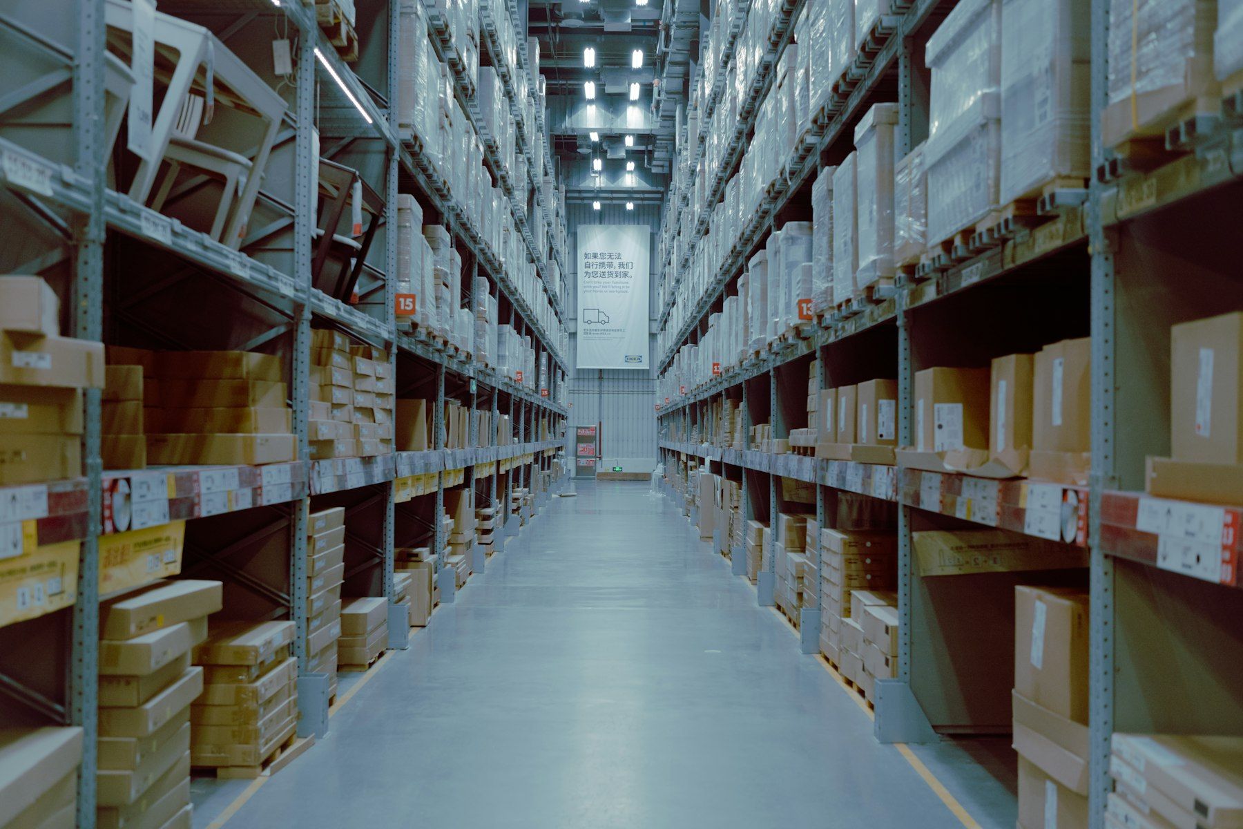 Long aisle of warehouse shelving stacked with boxed stock